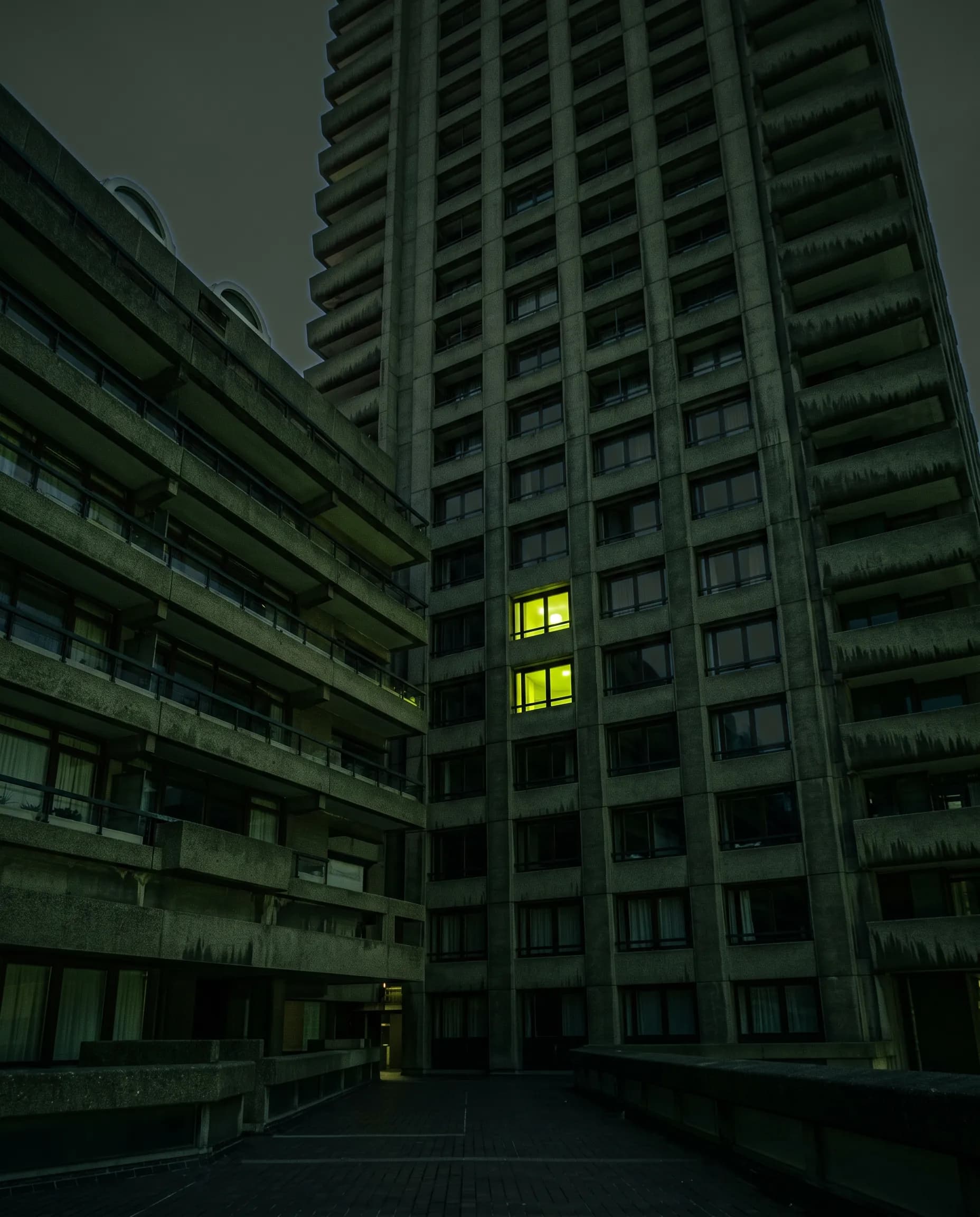 Brutalist concrete towers of the Barbican in London at dusk.